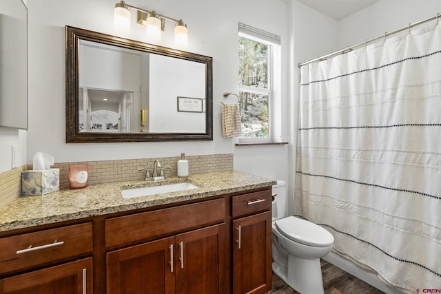 full bath with tasteful backsplash, a shower with shower curtain, toilet, and vanity