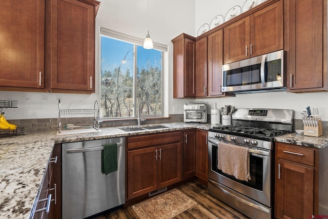 kitchen with dark wood-style floors, light stone countertops, visible vents, a sink, and appliances with stainless steel finishes