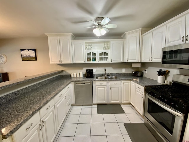 kitchen featuring a ceiling fan, a sink, stainless steel appliances, white cabinets, and light tile patterned floors