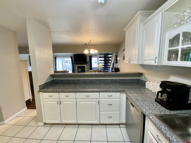 kitchen featuring dark countertops, white cabinetry, light tile patterned floors, dishwasher, and a chandelier