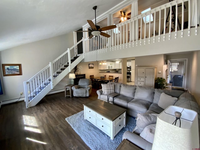 living room with stairway, wood finished floors, a high ceiling, and ceiling fan