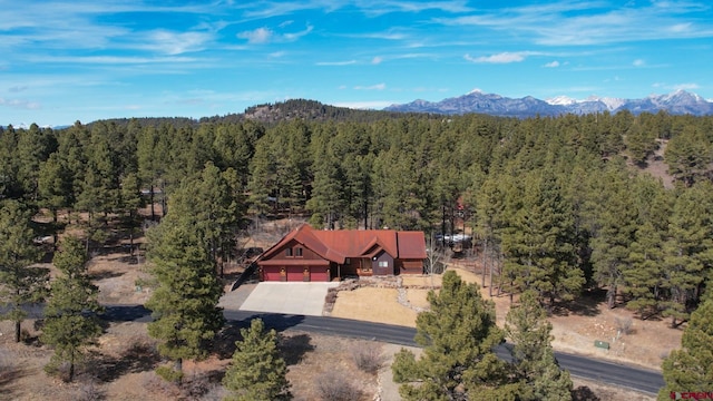 drone / aerial view featuring a forest view and a mountain view