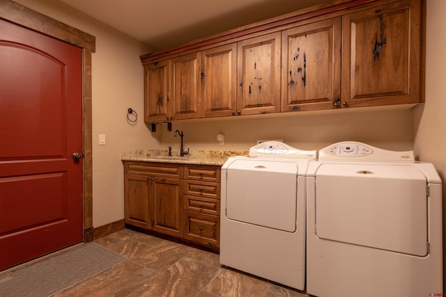 laundry area featuring a sink, cabinet space, and separate washer and dryer