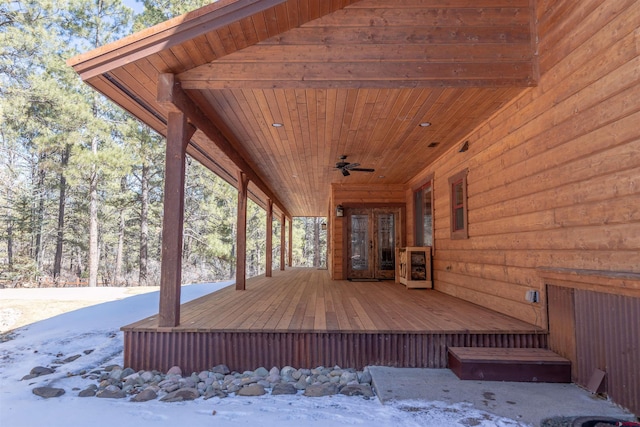 wooden terrace with a ceiling fan and french doors