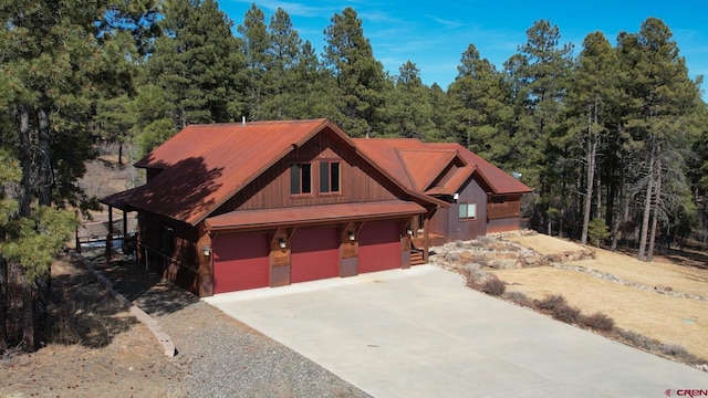 chalet / cabin featuring a forest view and a garage