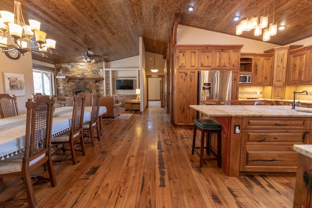 kitchen with brown cabinetry, appliances with stainless steel finishes, wooden ceiling, and a sink