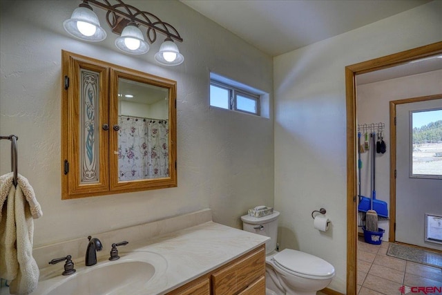 full bathroom with toilet, vanity, and tile patterned flooring