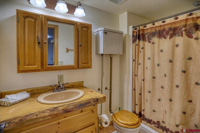 bathroom with curtained shower, toilet, and vanity