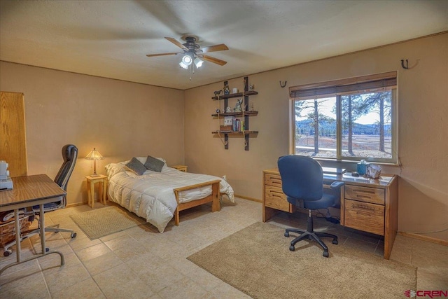 bedroom with a ceiling fan and baseboards