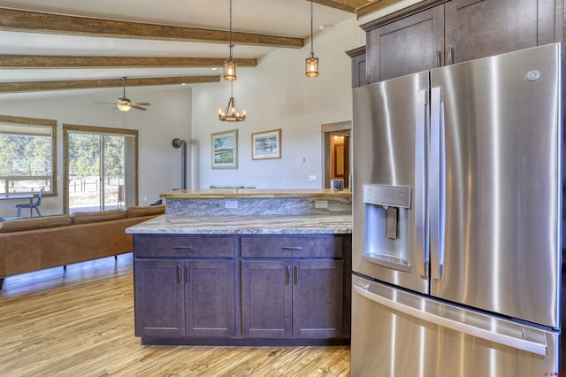 kitchen featuring stainless steel fridge, a peninsula, open floor plan, and light wood finished floors