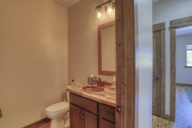 full bath with a shower stall, baseboards, toilet, wood finished floors, and vanity