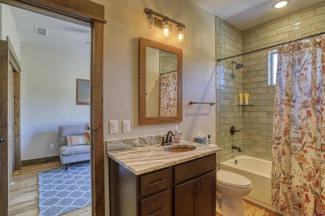 full bathroom with visible vents, shower / bathtub combination with curtain, wood finished floors, and vanity