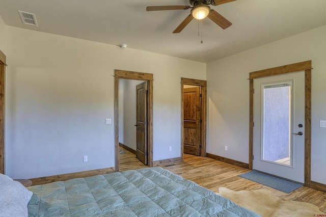 bedroom with visible vents, a ceiling fan, baseboards, and wood finished floors