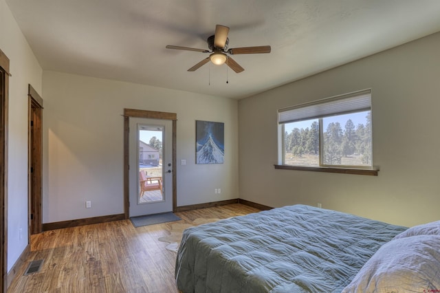 unfurnished bedroom featuring multiple windows, wood finished floors, and baseboards