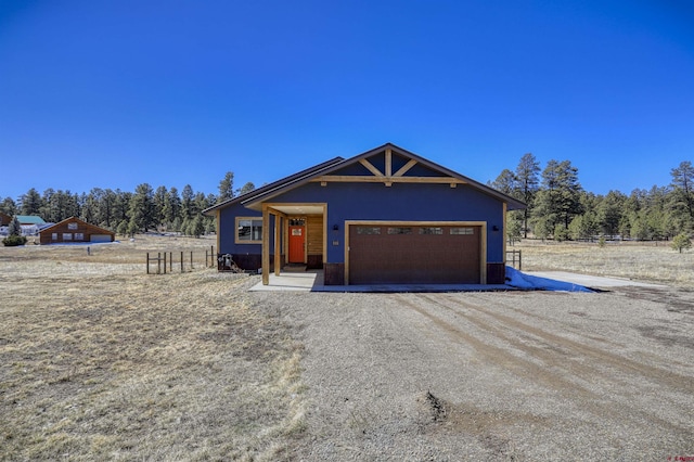 236 Arrowhead Dr, Pagosa Springs, CO 81147 - view of front of house with a garage, dirt driveway, and fence