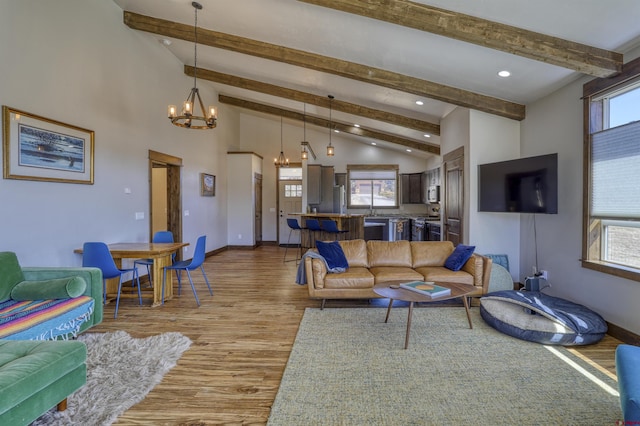 living room featuring plenty of natural light, a notable chandelier, and wood finished floors