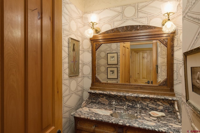 bathroom with wallpapered walls and vanity