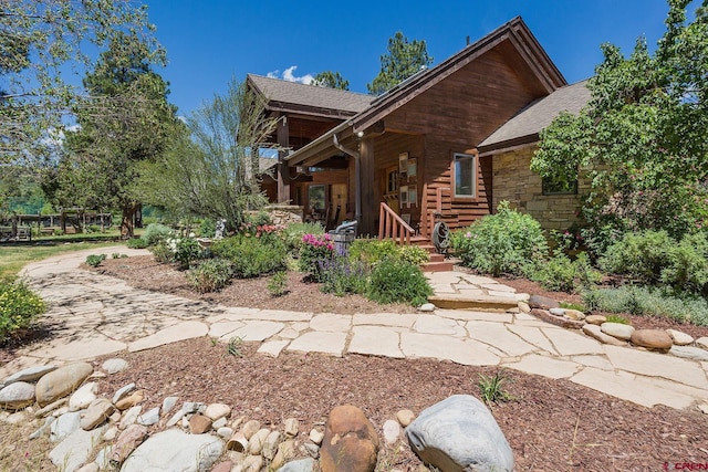 back of property featuring stone siding