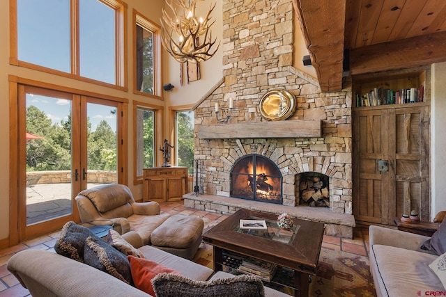 living room with a high ceiling, a fireplace, tile patterned flooring, french doors, and a chandelier