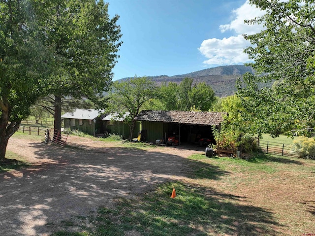 exterior space with an outdoor structure, fence, a mountain view, and a pole building