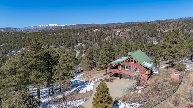 drone / aerial view featuring a mountain view and a view of trees