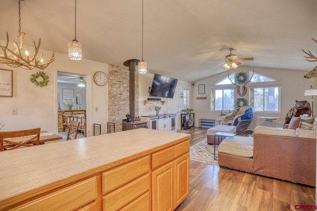 kitchen with open floor plan, light wood-style flooring, a ceiling fan, and vaulted ceiling