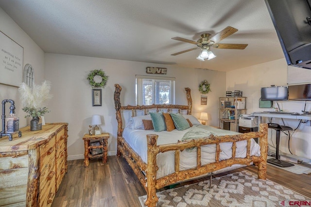 bedroom with baseboards, a textured ceiling, wood finished floors, and a ceiling fan