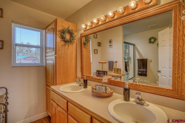 full bathroom featuring double vanity, visible vents, baseboards, and a sink