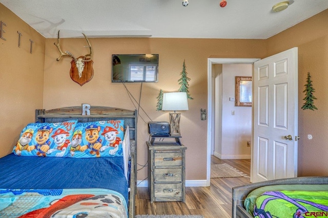 bedroom featuring baseboards and wood finished floors