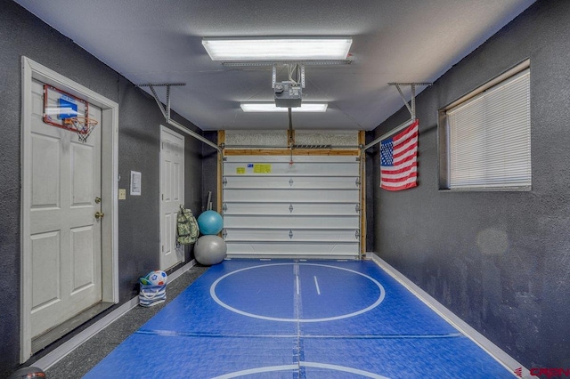 garage with a garage door opener and a textured wall