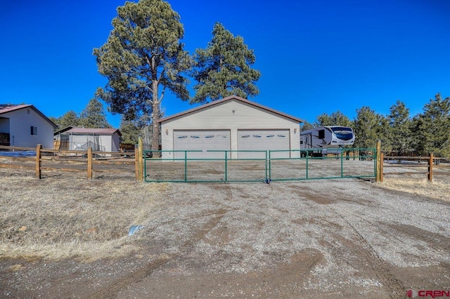 garage with driveway and fence