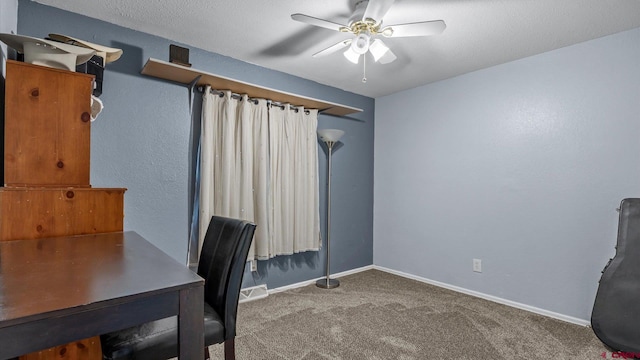 home office with a ceiling fan, baseboards, carpet floors, and a textured ceiling