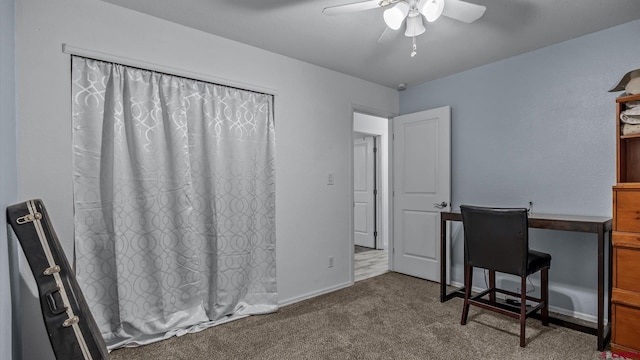 carpeted office space with baseboards and ceiling fan