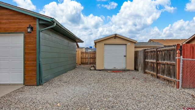 garage with a storage unit and fence