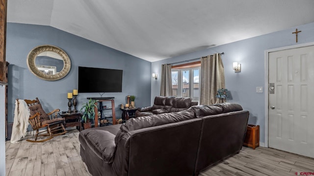 living area with light wood finished floors and vaulted ceiling