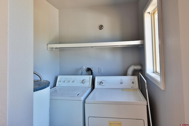 laundry room featuring washing machine and dryer, laundry area, and water heater