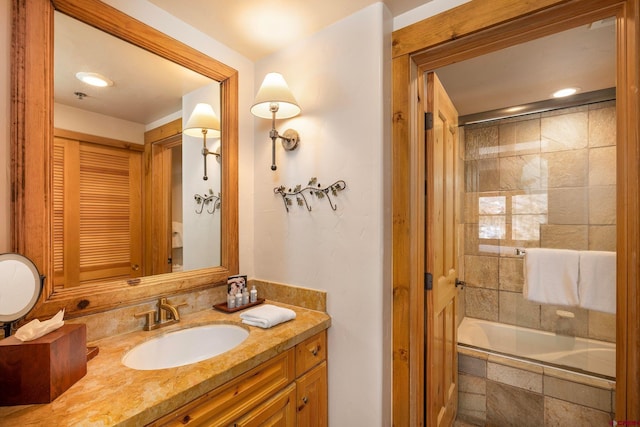 bathroom featuring tiled shower / bath and vanity