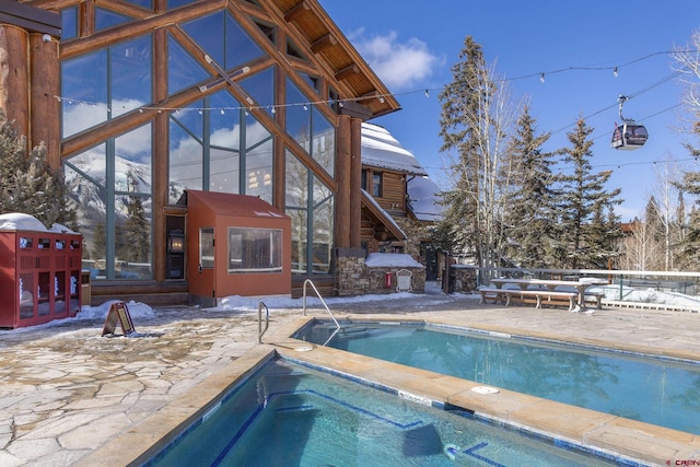 view of pool featuring a patio area, a fenced in pool, and an in ground hot tub