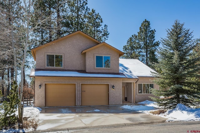 view of front of home with stucco siding, an attached garage, and concrete driveway