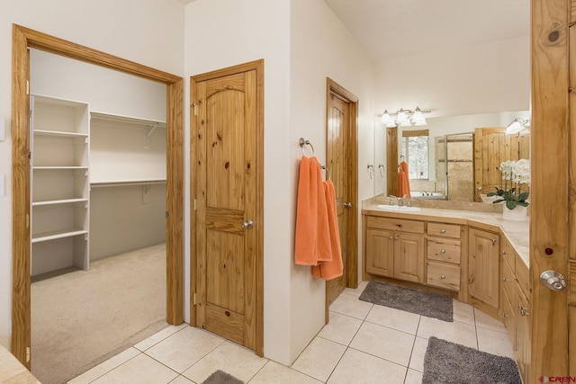 full bath featuring tile patterned flooring, a spacious closet, and vanity