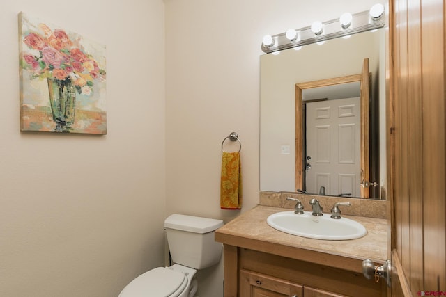 half bath featuring toilet and vanity