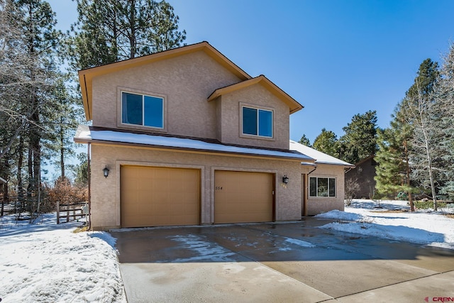 view of front of home featuring stucco siding, an attached garage, and driveway