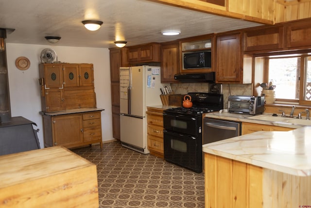 kitchen with ventilation hood, a sink, decorative backsplash, black appliances, and light countertops