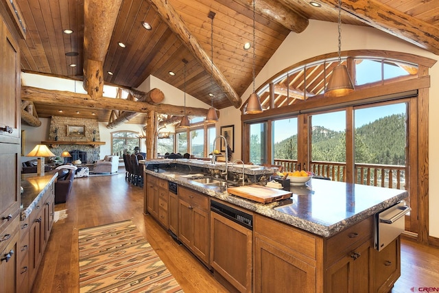 kitchen featuring light wood finished floors, open floor plan, paneled dishwasher, a warming drawer, and a sink