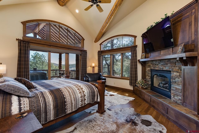 bedroom featuring multiple windows, wood finished floors, a fireplace, and access to exterior