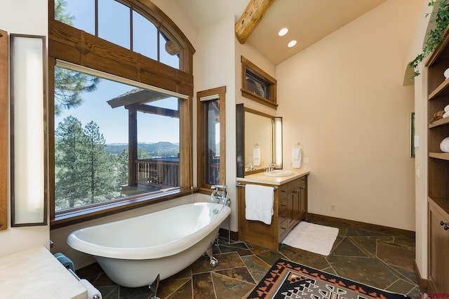 bathroom with vanity, baseboards, a soaking tub, recessed lighting, and stone tile flooring