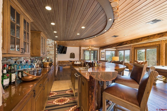 interior space featuring visible vents, light wood-type flooring, a notable chandelier, recessed lighting, and wood ceiling