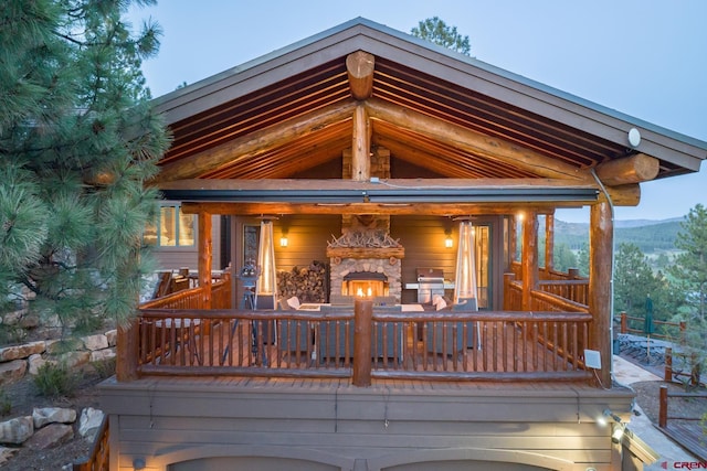 deck with an outdoor stone fireplace