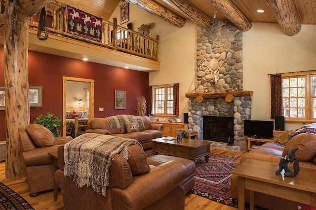 living area with a fireplace, wood ceiling, a high ceiling, and wood finished floors