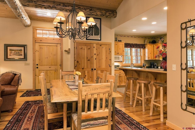 dining space featuring a chandelier, beamed ceiling, wooden ceiling, and light wood-style floors